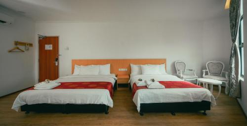 a bedroom with two beds and a table and chairs at 1 Million Hotel in Johor Bahru