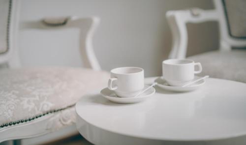 two white coffee cups sitting on a table at 1 Million Hotel in Johor Bahru