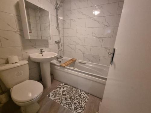 ein weißes Badezimmer mit einem Waschbecken, einem WC und einer Badewanne in der Unterkunft Cheerful 4 bedroom close to Uclan, Preston City Center in Preston