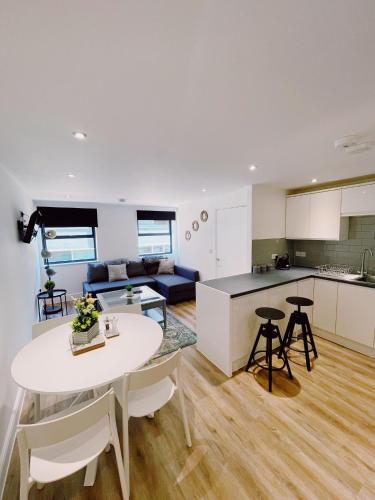 a kitchen and living room with a white table and chairs at Prosper House Apartment 4 in Norwich