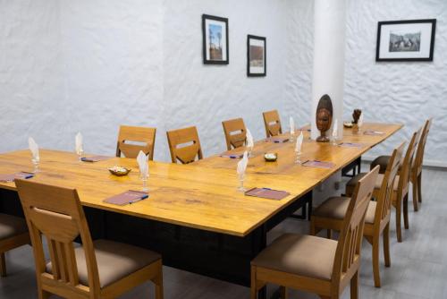 a large wooden table in a room with chairs at Le Lodge des Almadies in Dakar