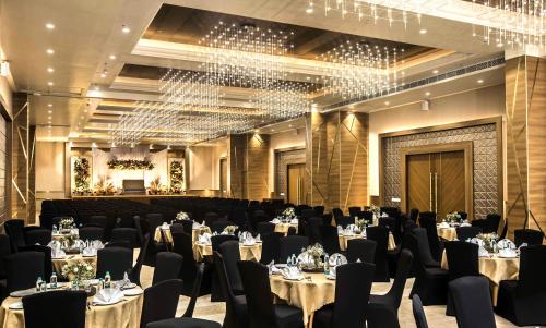 a banquet hall with tables and chairs and chandeliers at The Monarch Hotel & Convention Centre in Trivandrum