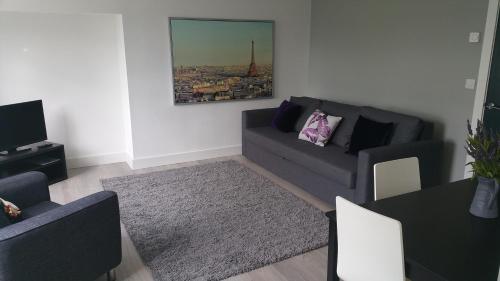 CityGo Apartments Queens Wellington في بلفاست: غرفة معيشة مع أريكة وطاولة