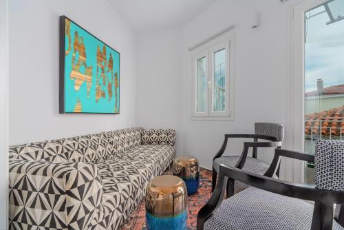 a living room with a couch and a table and chairs at Mare Gaia Apartments in Skiathos