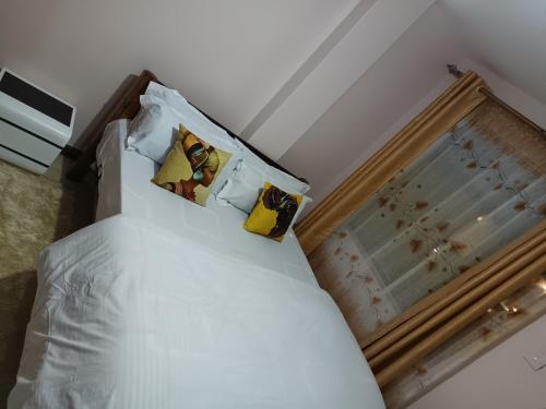 Bett mit weißer Bettwäsche und Kissen in einem Zimmer in der Unterkunft J.J homes 1- bedroom apartment, Nairobi in Nairobi