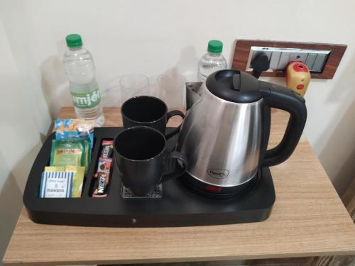 a tea kettle and cups on a counter at Joyous Rooms in Cherrapunji