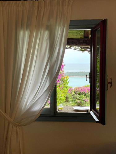 a window with a view of the ocean at SAN TEODORO PUNTA EST SPETTACOLARE QUADRILOCALE VISTA MARE in Capo Coda Cavallo