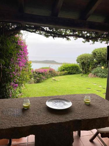 a table with two glasses and a plate on it at SAN TEODORO PUNTA EST SPETTACOLARE QUADRILOCALE VISTA MARE in Capo Coda Cavallo