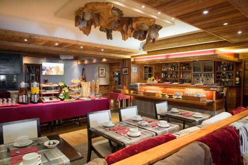 um restaurante com mesas e cadeiras num quarto em Park Hotel Suisse & Spa em Chamonix-Mont-Blanc