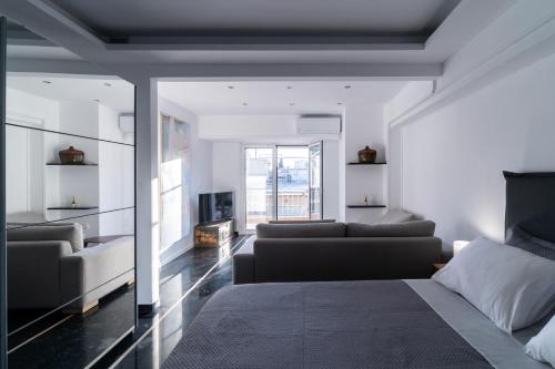 a bedroom with a bed and a couch and a fireplace at Luxury penthouse , breathtaking Acropolis view in Athens