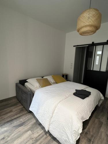 1 dormitorio con 1 cama grande con sábanas blancas en Appartement 4 personnes centre de Condom, en Condom