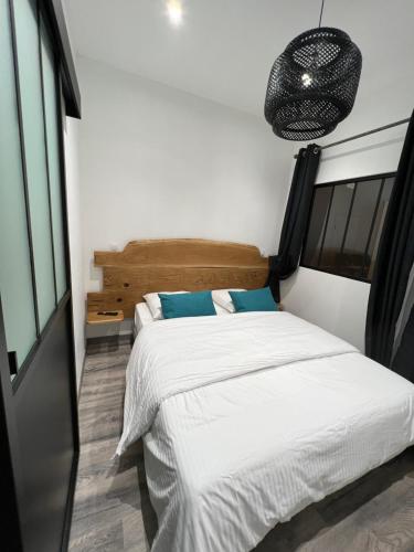 1 dormitorio con cama blanca y almohadas azules en Appartement 4 personnes centre de Condom, en Condom
