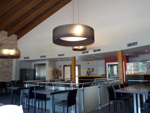 a dining room with tables and chairs and lights at Aparthotel Bubal in El Pueyo de Jaca