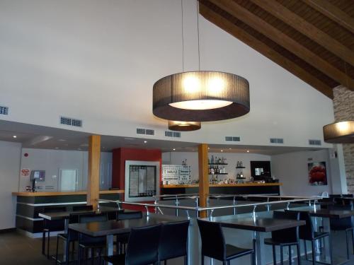 a restaurant with tables and chairs and a bar at Aparthotel Bubal in El Pueyo de Jaca