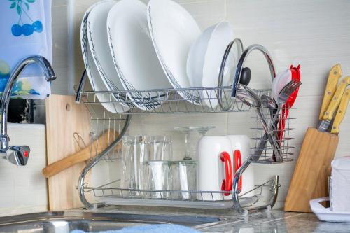a dish rack with plates and utensils on a kitchen counter at 1 BR FULLY FURNISHED NAKA in Nakuru