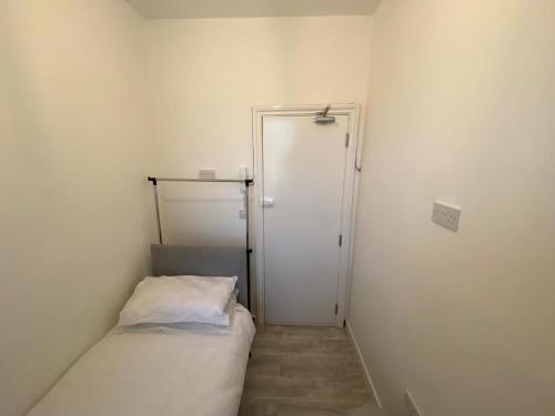 Habitación pequeña con cama y puerta en Small Single room walking distance to Hove Station, en Brighton & Hove