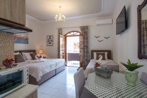 1 dormitorio con 1 cama grande y TV en Virvilis Apartments en Sivota