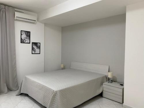 a white bedroom with a bed and a window at Napoli Residence Casalnuovo in Casalnuovo di Napoli