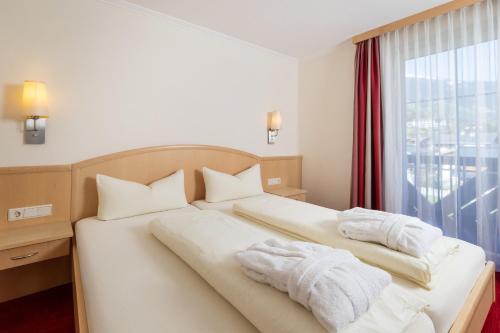 a hotel room with a bed with towels on it at Appartements Olympia in Mayrhofen