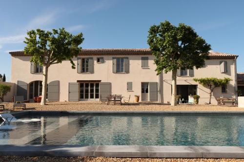 een huis met een zwembad voor een gebouw bij Le Mas Joséphine in Saint-Rémy-de-Provence