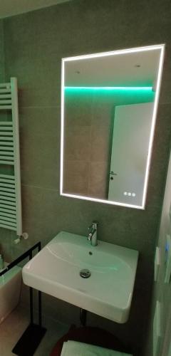 a bathroom with a white sink and a mirror at New Marina Apartments in Torri del Benaco
