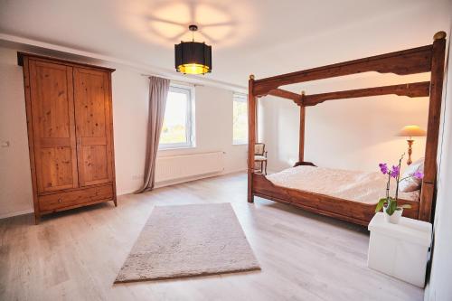 a bedroom with a canopy bed and a rug at Bildstein's "Dharamsala" in Langenfeld