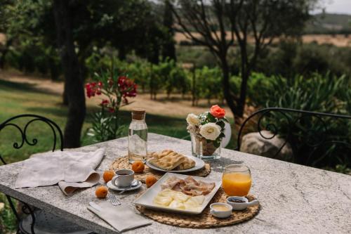 a table with a plate of food and orange juice at LOCANDA MURALES - Turismo rurale in Olbia