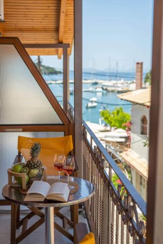 a table with books and wine glasses on a balcony at Virvilis Apartments in Sivota
