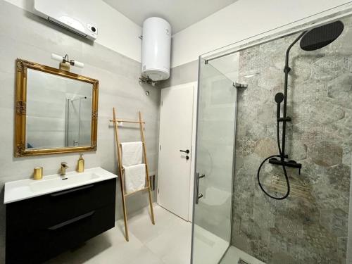 a bathroom with a sink and a shower with a mirror at Lux Apartmans in Pula