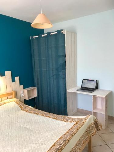 une chambre avec un lit et un bureau avec un ordinateur portable dans l'établissement Gîte de Leni - Maison avec piscine, à Torreilles