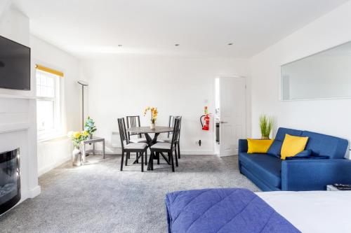 a living room with a blue couch and a table at Beach View Luxury Apartment in Lyme Regis