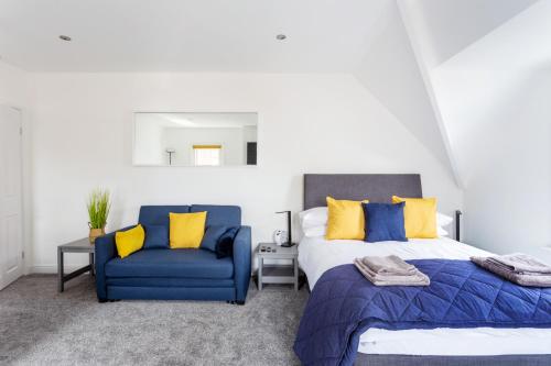 a bedroom with two beds and a blue chair at Beach View Luxury Apartment in Lyme Regis