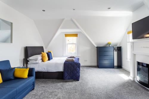 a bedroom with a bed and a blue couch at Beach View Luxury Apartment in Lyme Regis