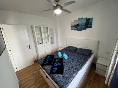 sypialnia z łóżkiem i wentylatorem sufitowym w obiekcie Teneryfa -apartament z cudownym widokiem na ocean. w mieście Puerto de Santiago