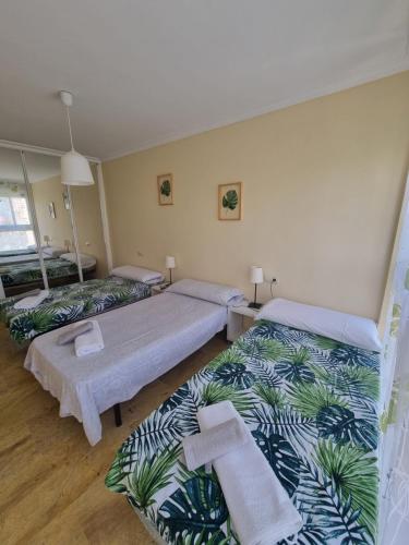 sypialnia z 2 łóżkami i ręcznikami w obiekcie Bungalow Puig Campana con barbacoa w mieście Benidorm