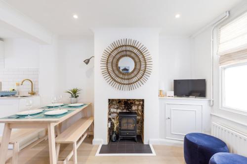 a dining room with a table and a fireplace at Central quiet cottage. Walk to shops, bars & beach in Brighton & Hove