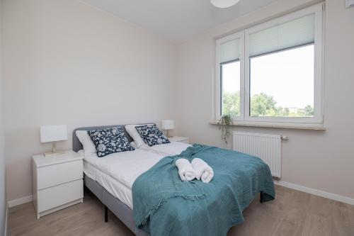 a white bedroom with a bed with towels on it at ShortStayPoland Pohulanka (B85) in Warsaw