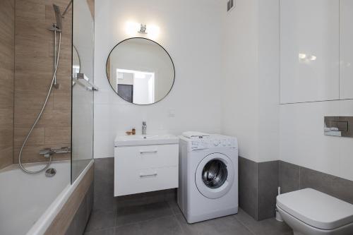 a bathroom with a washing machine next to a toilet at ShortStayPoland Pohulanka (B85) in Warsaw