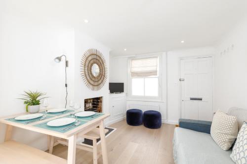 a white living room with a table and a couch at Central quiet cottage. Walk to shops, bars & beach in Brighton & Hove