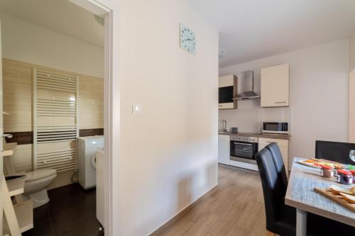a kitchen with a toilet and a table in a room at Bazaltorgona Apartman in Kisapáti