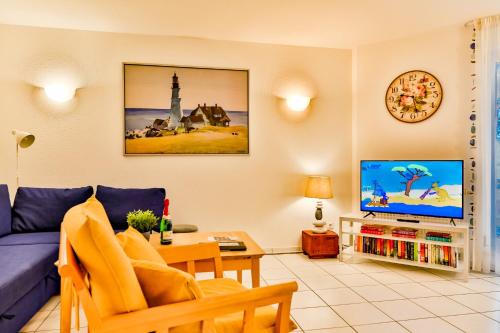 a living room with a blue couch and a tv at Apartment Ostseerose in Zempin