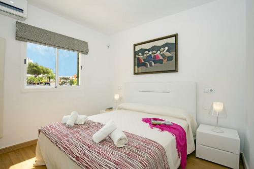 een witte slaapkamer met een bed en een raam bij Villa Oleanda by Villa Plus in Port d'Alcudia