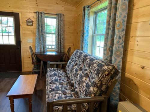 a living room with a couch and a table and windows at Lincoln Log Cabins in Lincoln