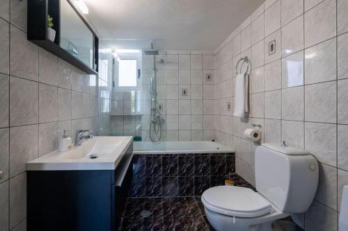 a bathroom with a toilet and a sink and a tub at Eden’s garden in Chania Town