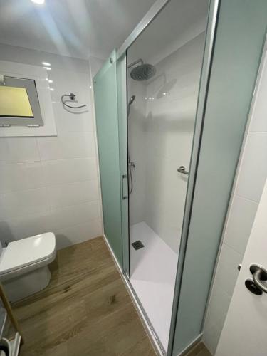 y baño con ducha y aseo. en Apartament Edifici Simbat a 150m de la platja, en Palamós