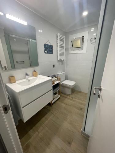 y baño con lavabo blanco y aseo. en Apartament Edifici Simbat a 150m de la platja, en Palamós