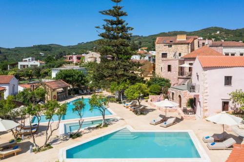 a villa with a swimming pool and a resort at Spilia Village Hotel & Villas in Spiliá