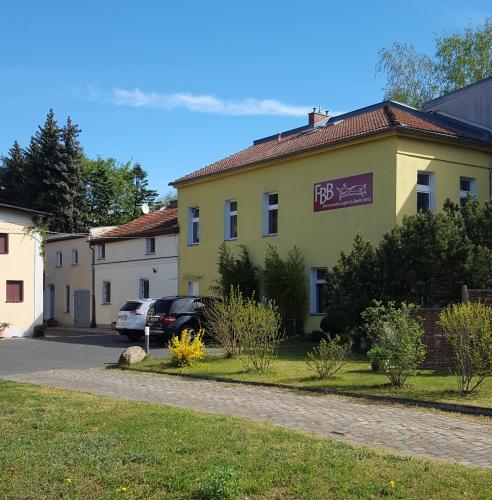 a yellow building with a sign on it at 1 Zimmer Apartment mit bis zu 4 Schlafplätzen, separate Küche und Bad mit Garten und Parkplatz in Berlin