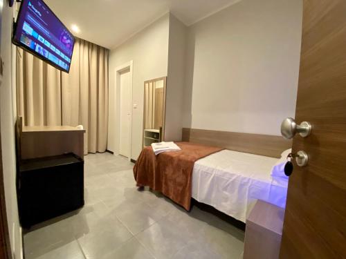 a hotel room with a bed and a flat screen tv at Hotel Vintage Milano Centrale in Milan