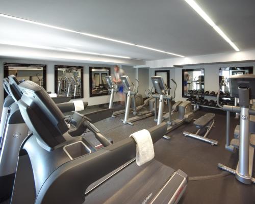 a gym with a row of treadmills and mirrors at Hard Rock Hotel San Diego in San Diego